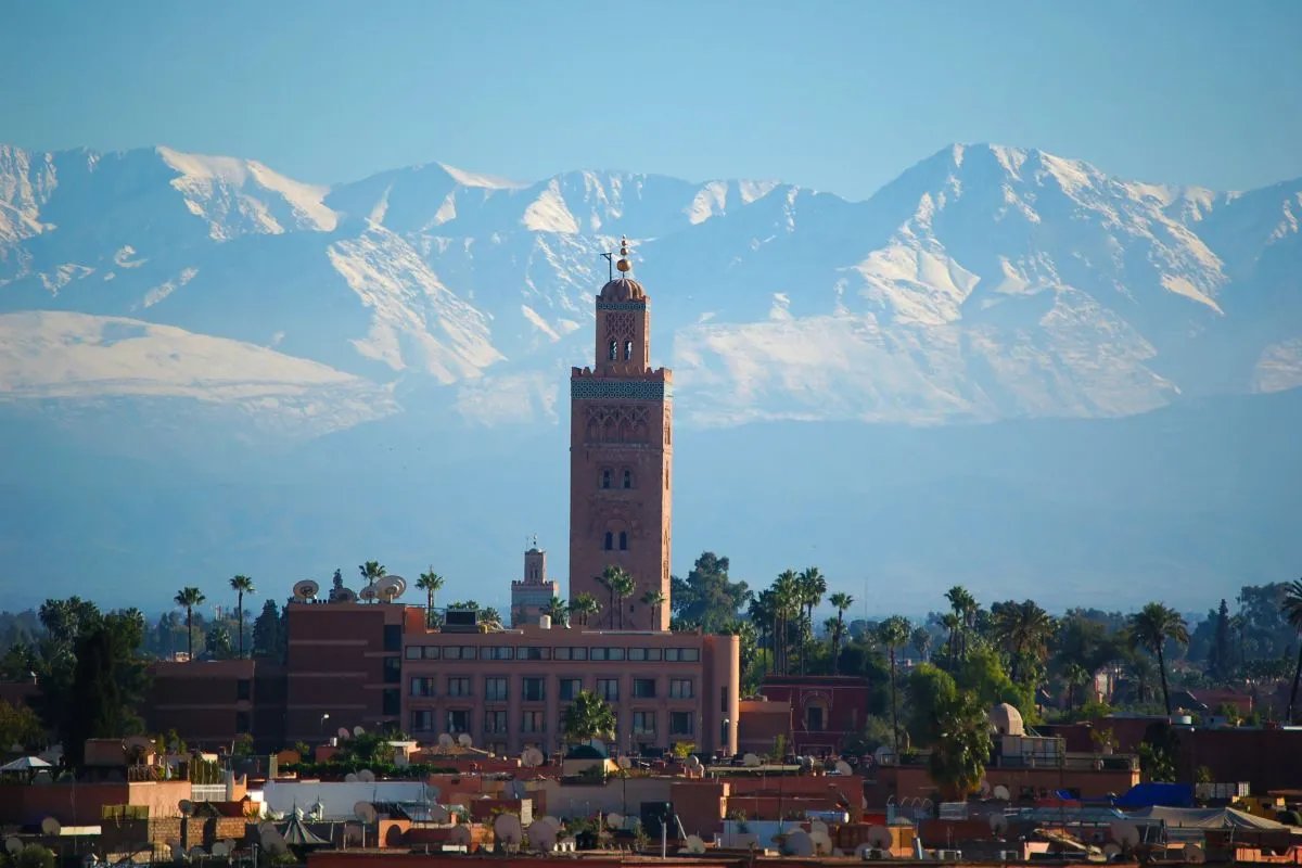 Photo : Domenico Bertazzo / Pexels El Badi Palace in Marrakech under a clear blue sky with a reflecting pool in the foreground.